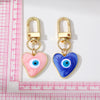 Gold heart-shaped keychain featuring a blue and white evil eye design.