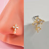 Gold-toned surgical steel demon angel nose studs on a pink ear model.