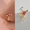 Gold-toned surgical steel demon angel nose studs featuring a pink gemstone and diamond accents.