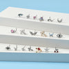 A collection of surgical steel demon angel nose studs displayed on a white surface.
