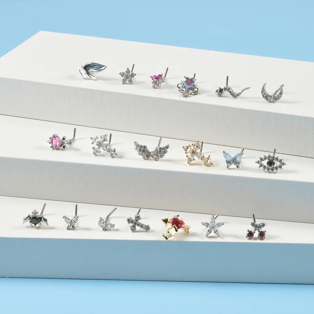 A collection of surgical steel demon angel nose studs displayed on a white surface.
