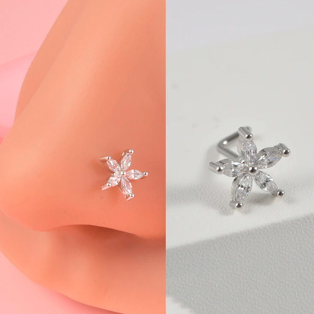 Silver surgical steel demon angel nose studs on a pink skin model.