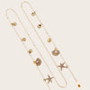 Collier délicat en métal or et perles en forme d'étoile de mer, présenté sur fond neutre.