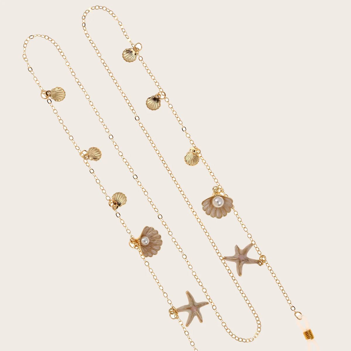 Collier délicat en métal or et perles en forme d'étoile de mer, présenté sur fond neutre.