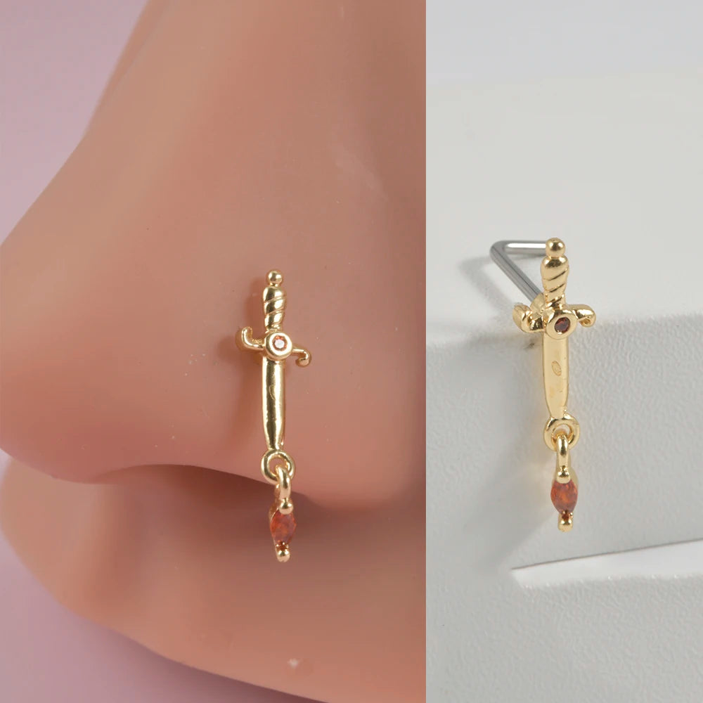 Gold surgical steel demon angel nose studs with a small ruby accent