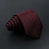 A dark red plaid men's tie is rolled and displayed against a black background.