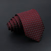 A dark red patterned men's tie rolled up and displayed against a black background.