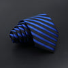 A dark blue and black striped necktie is tightly folded on a dark surface.