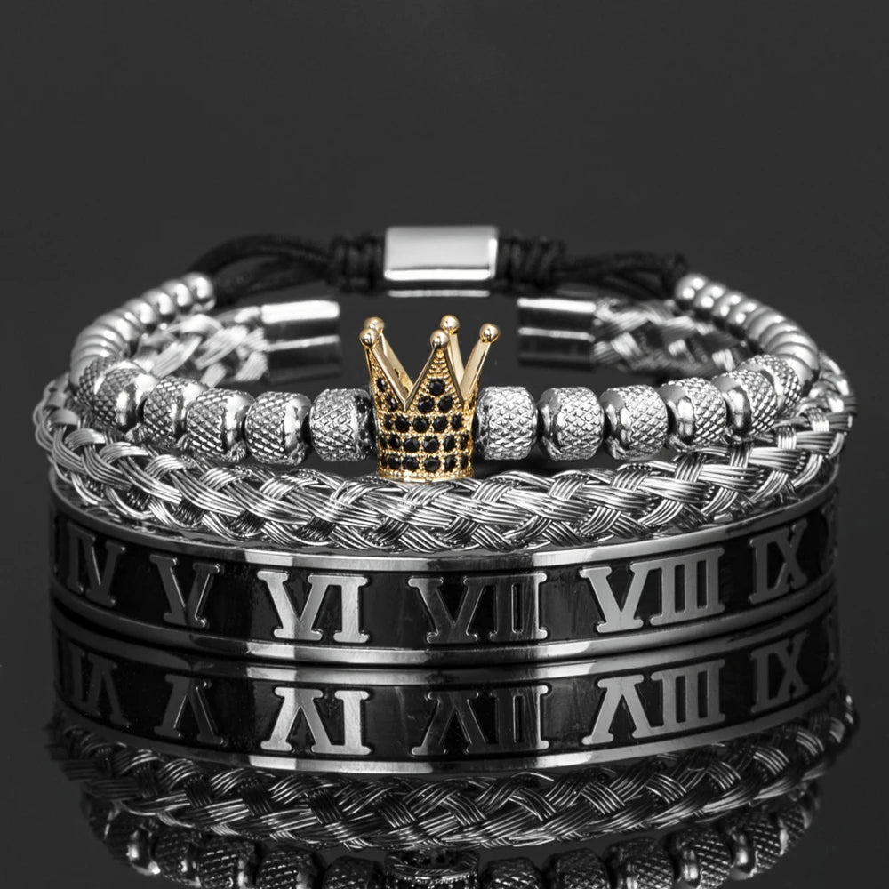 Una pila de pulseras de esmalte de plata y oro con números romanos, mostradas sobre una superficie reflectante.