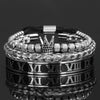 Pila de pulseras de esmalte plateadas y negras con diseño de números romanos y corona