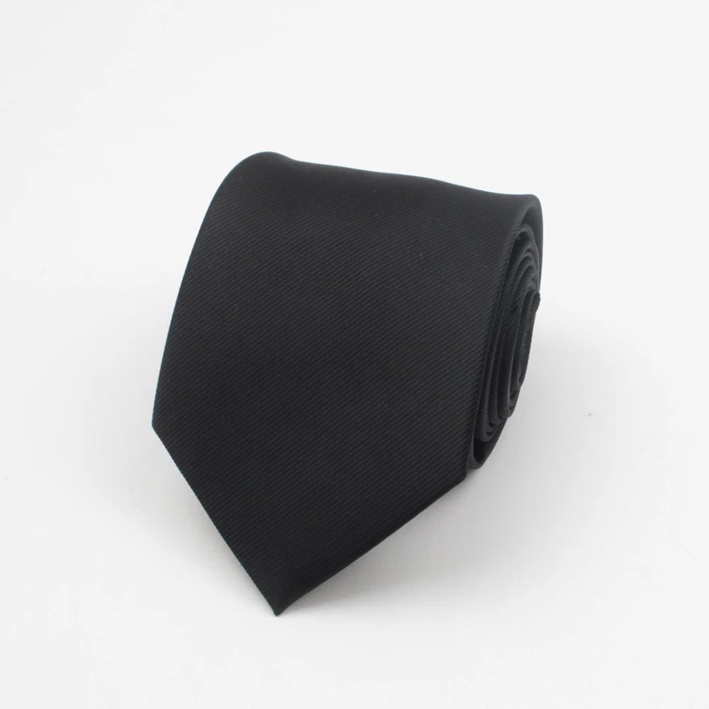 Black necktie with a subtle stripe pattern folded neatly.