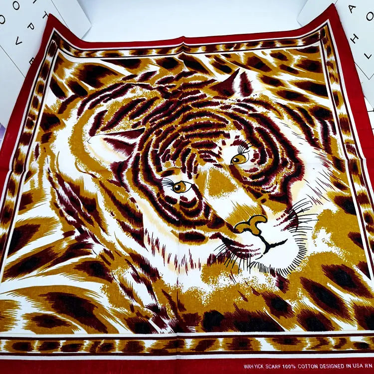 Primer plano de una bufanda con estampado de tigre en tonos dorados, marrones y blancos.