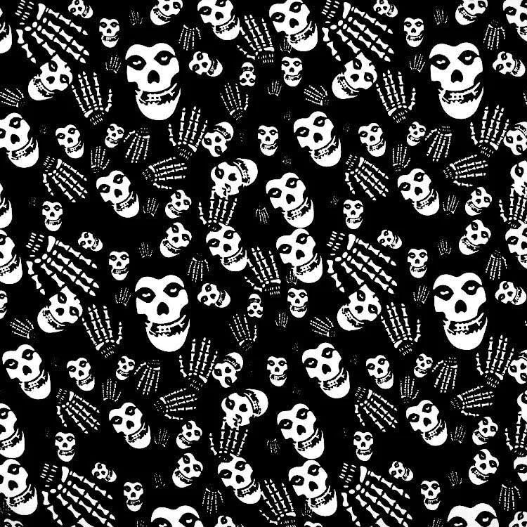 Patrón negro de calaveras blancas en fondo de tela.