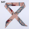 A pink silk headband scarf featuring a multi-color design with chain motifs.