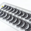 A display of dramatic mink false eyelashes arranged in a row on a white tray.
