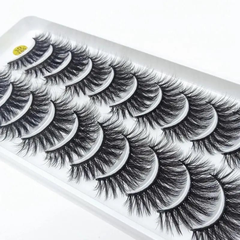 A display of dramatic mink false eyelashes arranged in a row on a white tray.