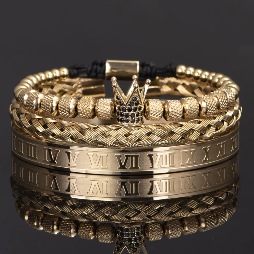 Pulseras de esmalte dorado y negro con números romanos apilados sobre una superficie reflectante.