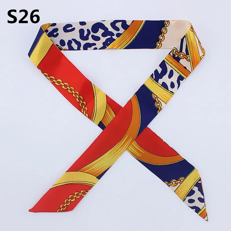 A silk headband scarf featuring a multi-color pattern with leopard print and gold chain details.