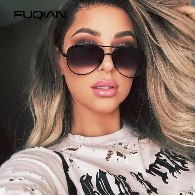 A woman wearing classic metal aviator sunglasses with a gradient black driver style on her face.