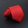 A red silk tie with a repeating pattern of small silver plaid dots, rolled and displayed against a dark background.