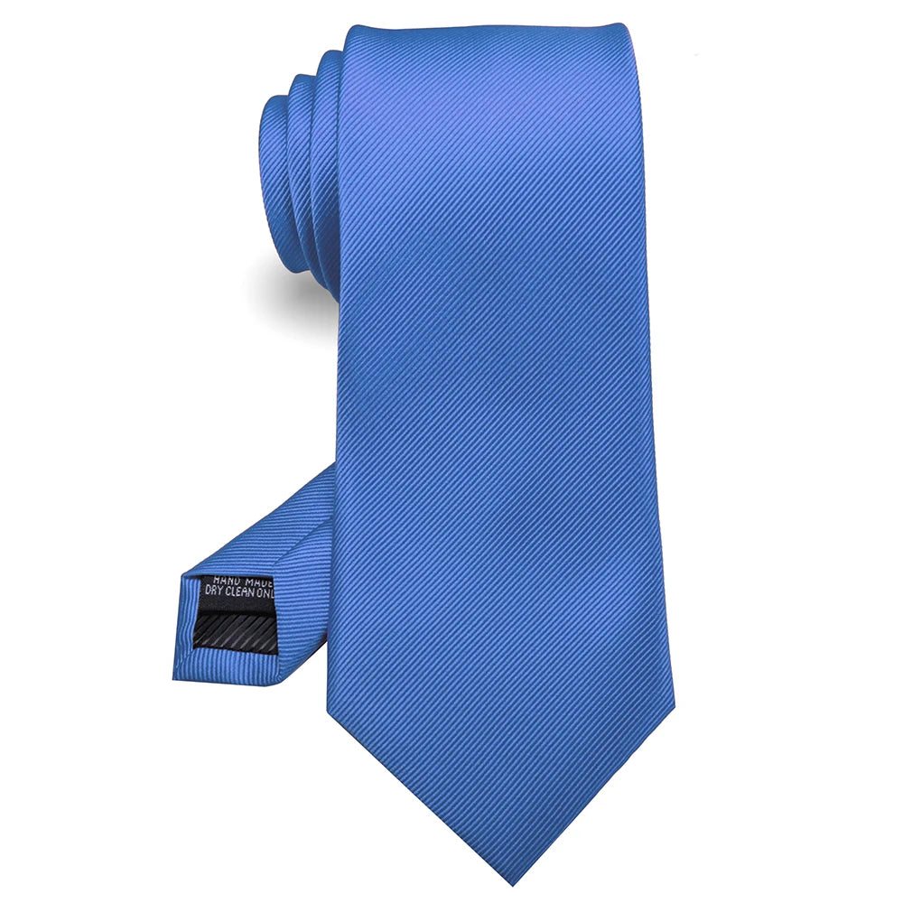 Cravate en soie jacquard bleu solide pliée et présentée sur fond blanc.