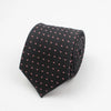 Black necktie with a small red dot pattern rolled up.