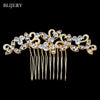 A gold-toned bridal hair comb tiara adorned with clear rhinestones and dangling strands.