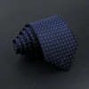 A dark blue patterned men's tie with small gold plaid dots, rolled and displayed on a dark surface.