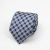 A folded blue and white patterned necktie with a geometric stripe and dot design.