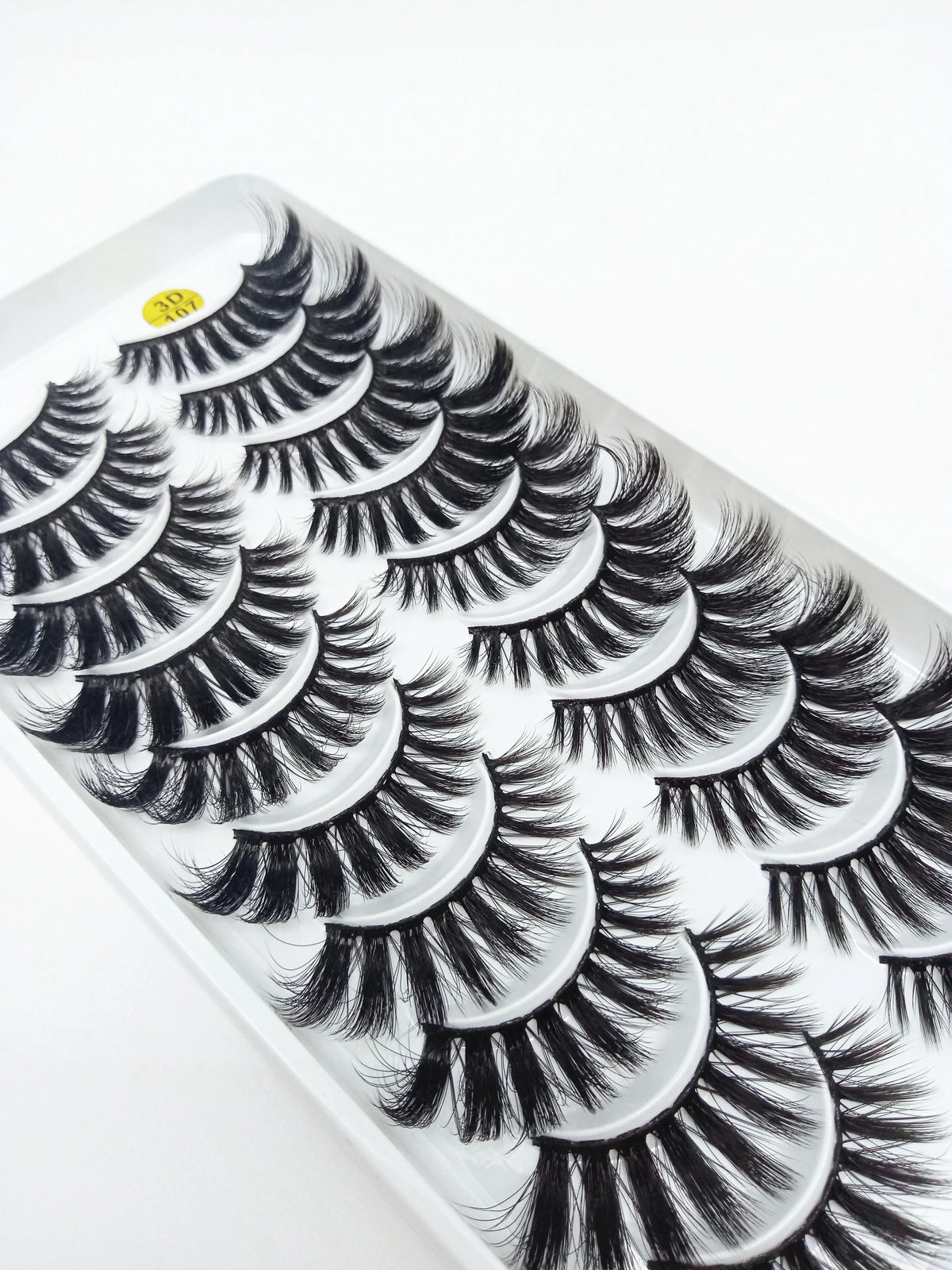 A close-up of a tray of dramatic mink false eyelashes with long, voluminous lashes.