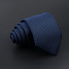 A dark blue patterned men's tie rolled into a spiral shape.
