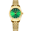 A gold-toned wristwatch with a green face and gold accents, featuring a textured metal band.