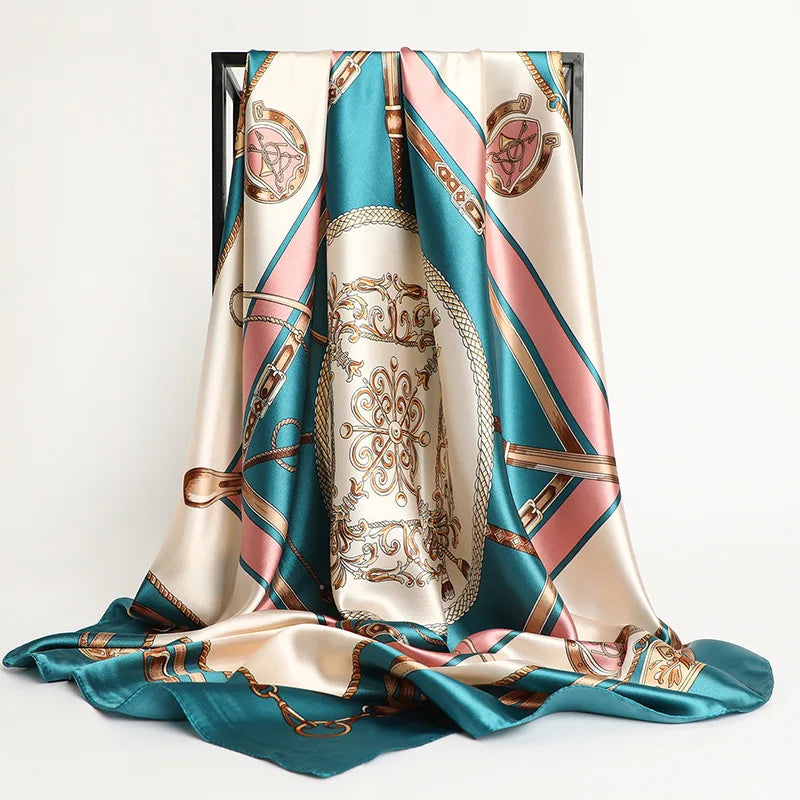 A luxurious satin silk scarf in teal and pink tones draped elegantly.