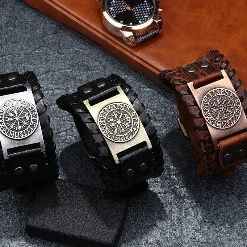 A close-up of a retro leather pirate compass bracelet for men resting on a dark surface.