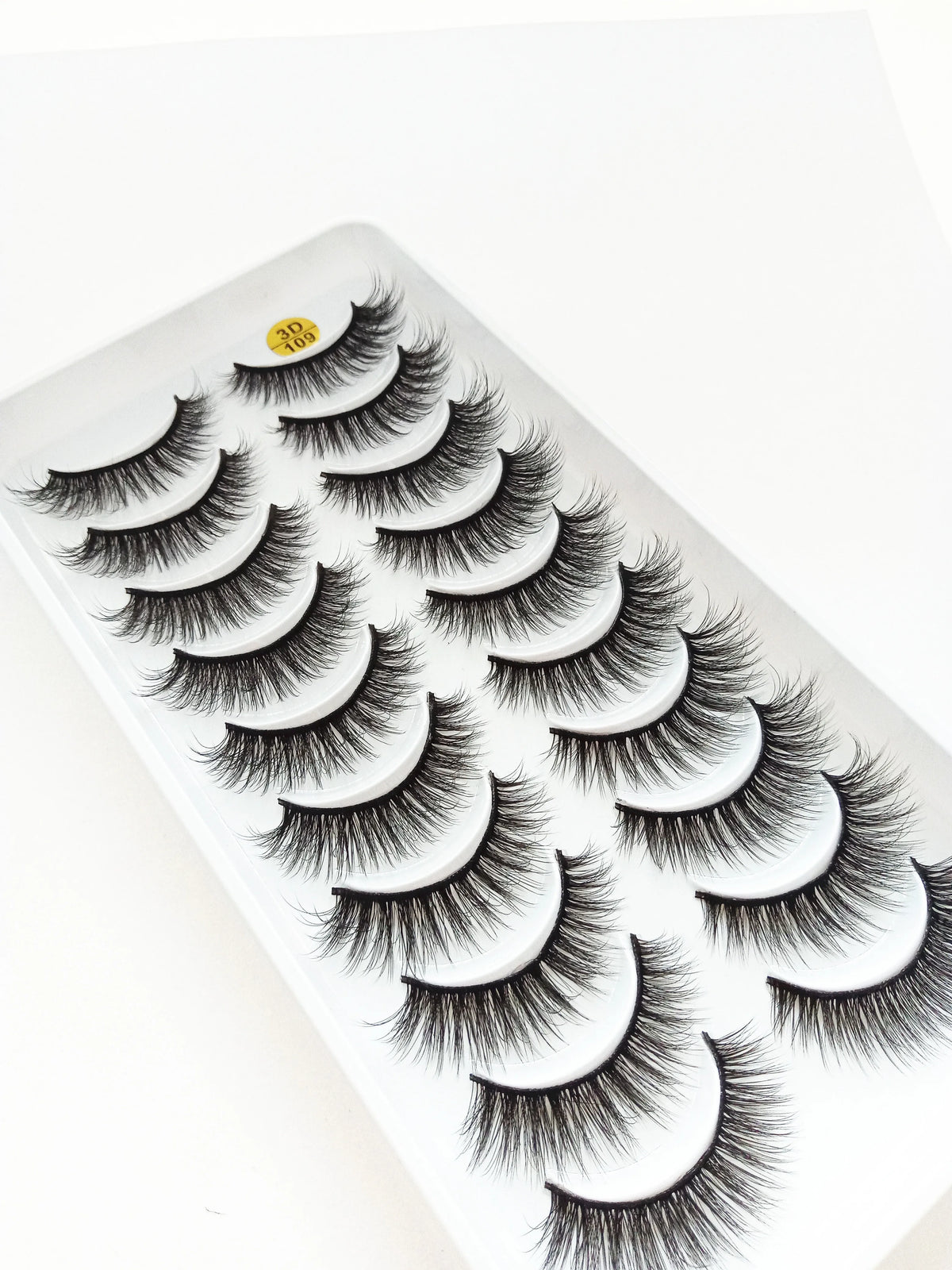 A display of dramatic mink false eyelashes on a white tray.