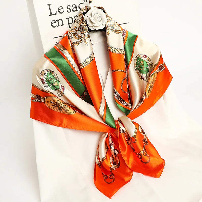 A luxurious satin silk scarf featuring an orange and green pattern tied around a white shirt.