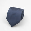 A dark blue necktie with a subtle pattern of small white dots, rolled and displayed on a white background.