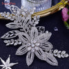 Glitzernde Strass-Brauttiara mit floralen und blattartigen Designs auf dunkler Oberfläche.