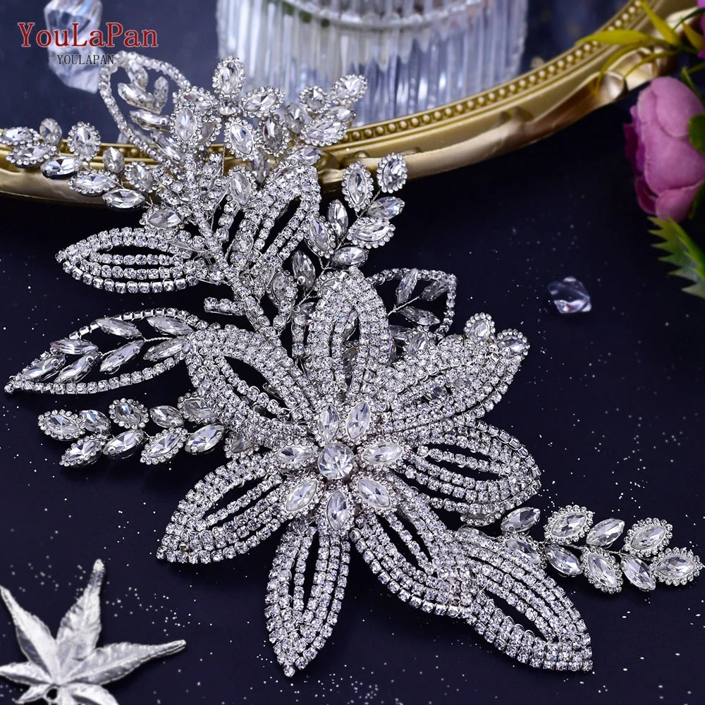Glitzernde Strass-Brauttiara mit floralen und blattartigen Designs auf dunkler Oberfläche.