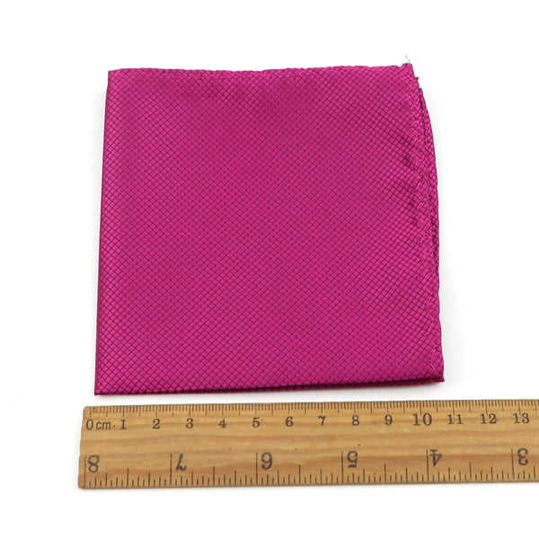 A vibrant magenta silk satin men's pocket square folded neatly on a wooden ruler.