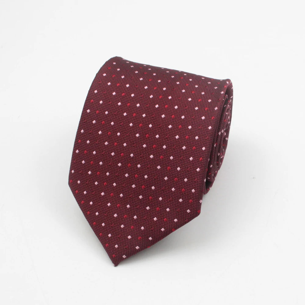 A maroon necktie with a small red dot pattern, folded and displayed against a white background.