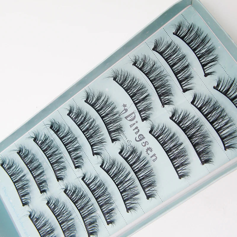 A display of black mink false eyelashes arranged in rows on a light blue tray.