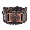 A dark brown leather bracelet featuring an engraved compass design and a bronze accent plate.