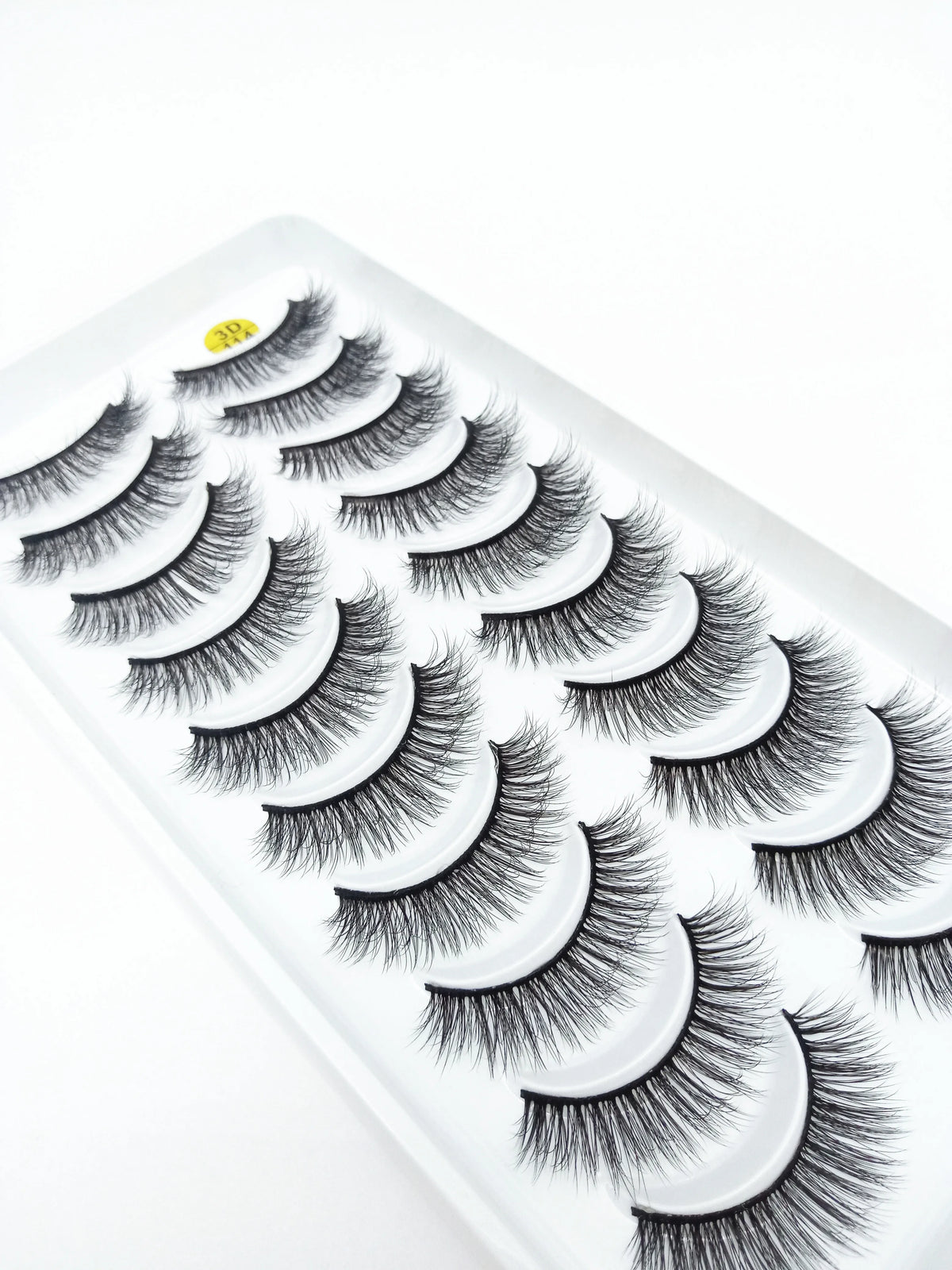 A display of dramatic mink false eyelashes on a white plastic tray.