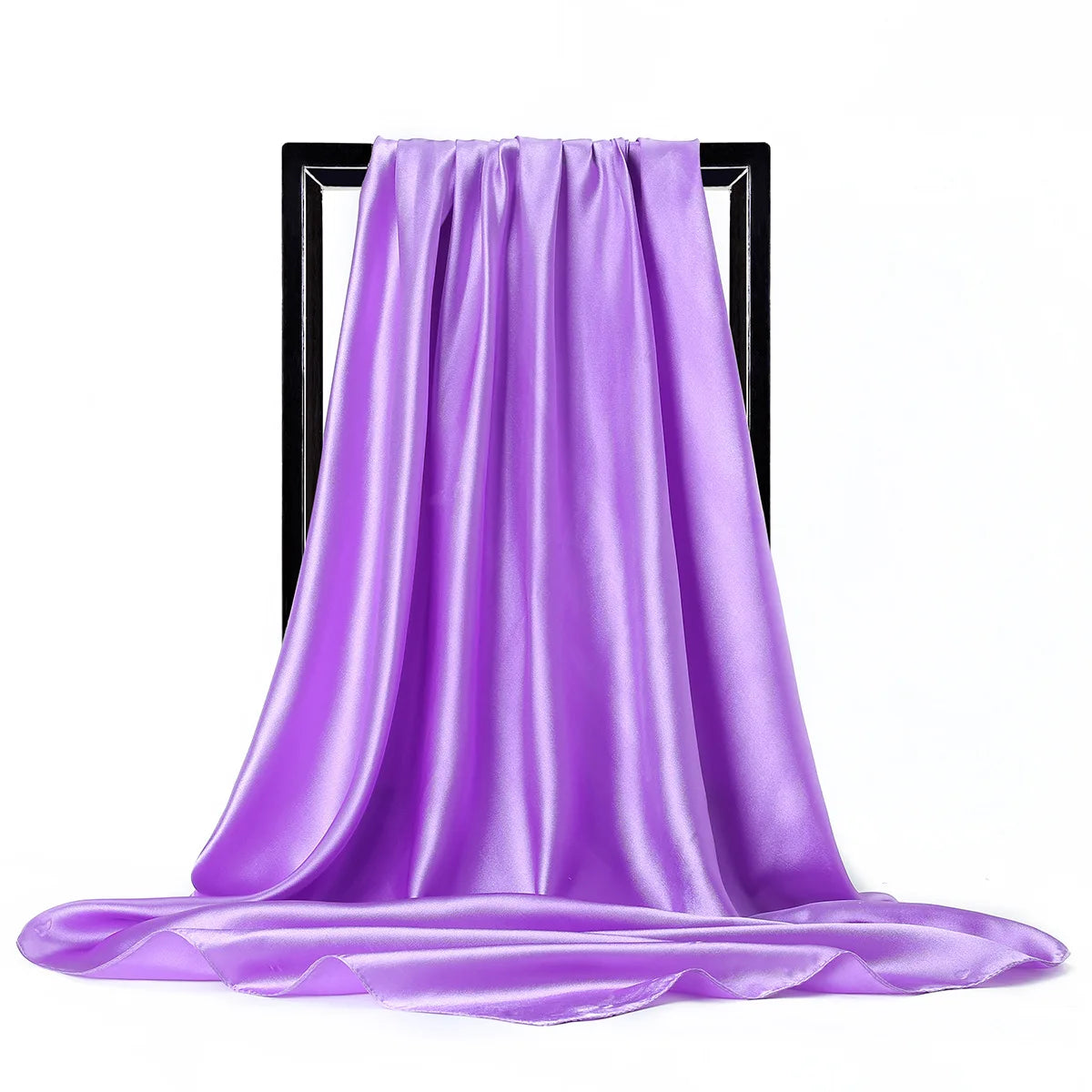 Una bufanda de seda satinada morada drapeada sobre un soporte negro.