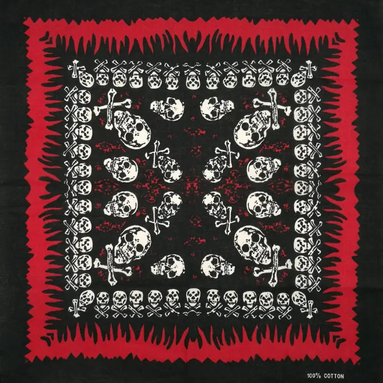 Diseño de tela cuadrada roja y negra con calaveras y cruces blancas, similar a una bandana o pañuelo decorativo.
