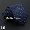 A dark blue patterned necktie with small light dots, shown rolled and draped.