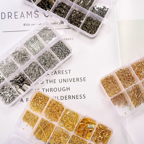 A collection of silver, gold, and brass jewelry findings including clasps, hooks, and jump rings in clear plastic containers.