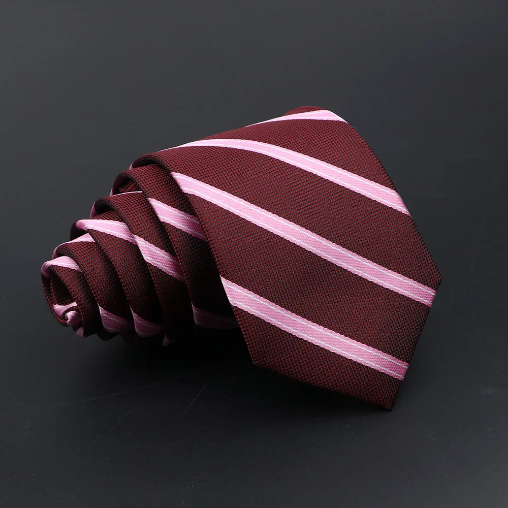 A maroon tie with diagonal pink stripes is rolled and displayed against a dark background.