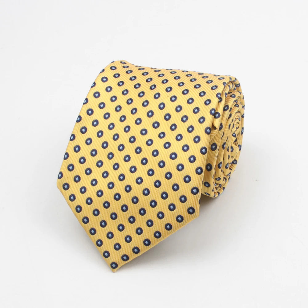 A yellow necktie with a blue dot pattern folded and displayed against a white background.